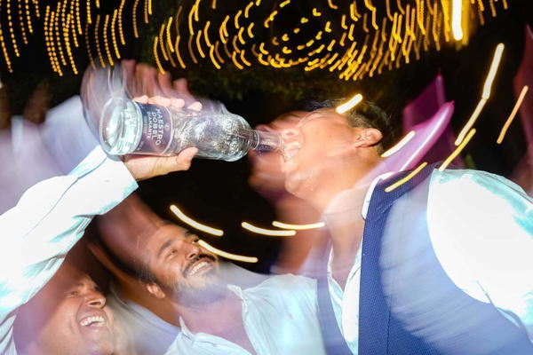 A group of people drinking from a bottle